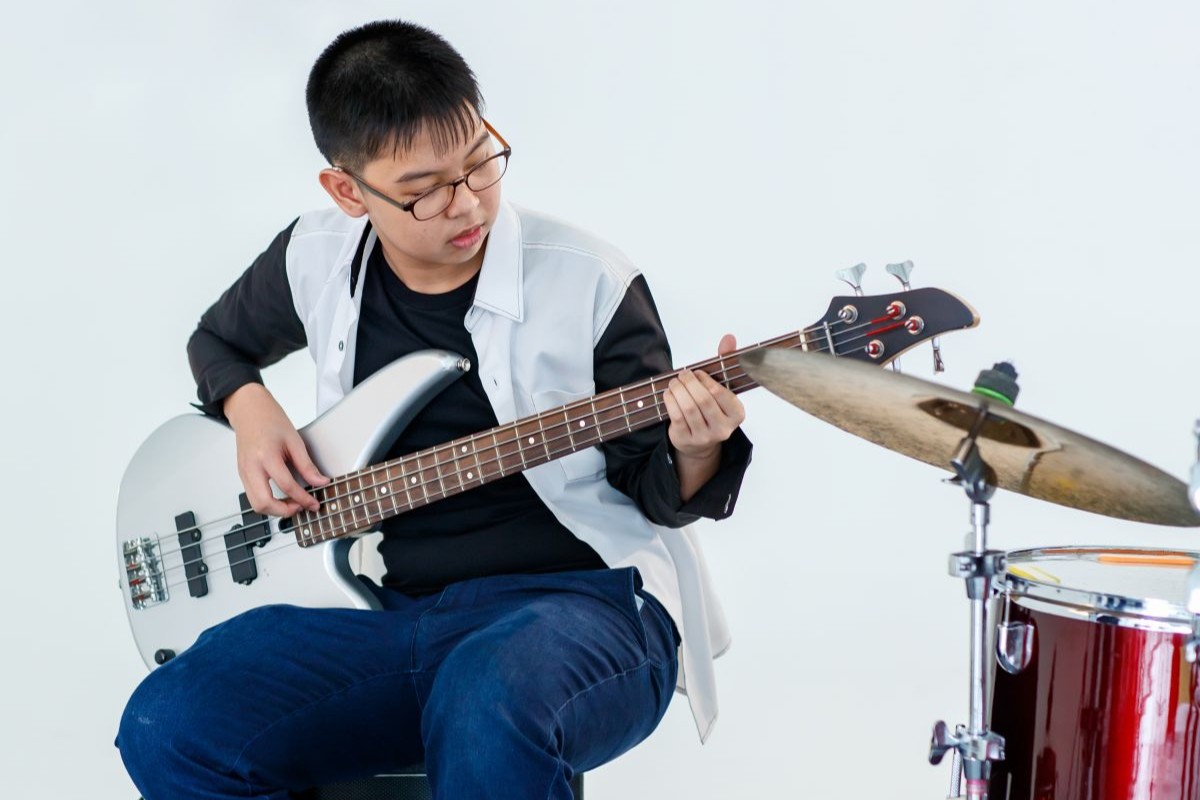A man and woman playing the Bass Guitar together